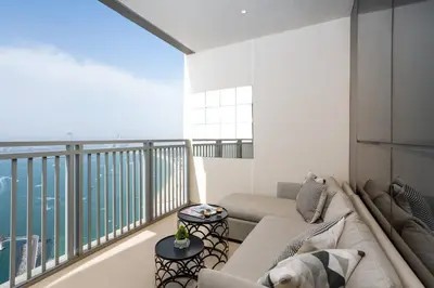 a dog is sitting on a couch on a balcony at Waves - 52 42 Emaar, Tower 1 in Dubai