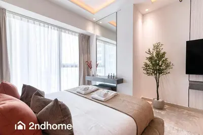 a bedroom with a large bed and a tv at 2ndHome - Me Do Re , Cluster L, JLT in Dubai