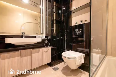 a bathroom with a toilet and a sink and a tub at 2ndHome - Me Do Re , Cluster L, JLT in Dubai