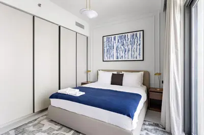 a bedroom with a large bed with a blue blanket at Silkhaus Sea View Stunning 1BDR with Private Beach in Dubai