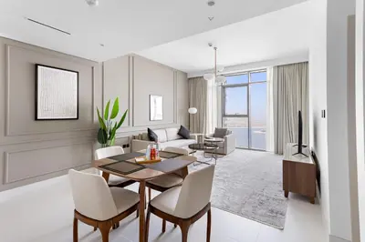 a living room with a table and chairs and a couch at Silkhaus Sea View Stunning 1BDR with Private Beach in Dubai