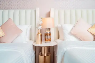 a bedroom with two beds and a vase with flowers at Elite Royal Apartment - Full Burj Khalifa & Fountain View - Luxurious - Viceroy in Dubai