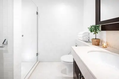 a white bathroom with a toilet and a shower at Elite Royal Apartment - Full Burj Khalifa & Fountain View - Luxurious - Viceroy in Dubai