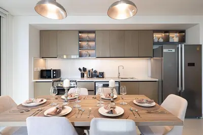a kitchen with a wooden table with chairs and a dining room at Burj Crown - Downtown Elegance Opera Boulevard View by Dubai Mall in Dubai