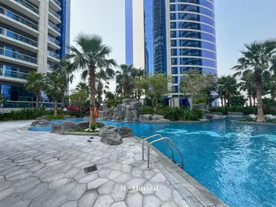 a swimming pool with palm trees and buildings at Manzil - 1BR Apartment in Paramount with Top-Floor Luxury Living in Dubai