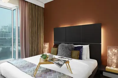 a bedroom with a large bed and a large window at Maison Privee - Cosmopolitan Apt with Scenic Dubai Marina Vws in Dubai