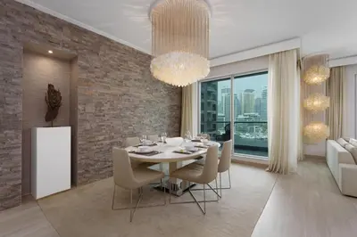 a dining room with a white table and chairs at Maison Privee - Cosmopolitan Apt with Scenic Dubai Marina Vws in Dubai