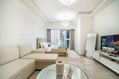a living room with a couch and a tv at SettlerHomes - Upscale JLT Stay Near Metro in Dubai