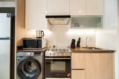 a kitchen with a washing machine and a microwave at SettlerHomes - Upscale JLT Stay Near Metro in Dubai
