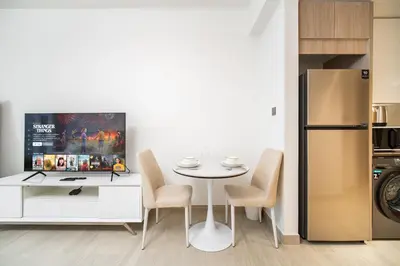 a kitchen with a table and chairs and a refrigerator at SettlerHomes - Upscale JLT Stay Near Metro in Dubai