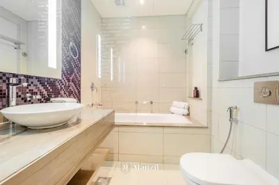 a bathroom with a sink and a tub and a toilet at Manzil - 1BR Apt with Pool close to Downtown in Dubai