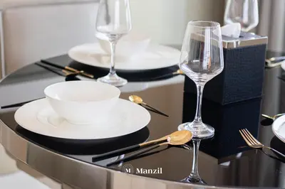 a table with two glasses and a bowl and plate at Manzil - 1BR Apt with Pool close to Downtown in Dubai