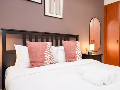 a bedroom with a large bed with pink and white pillows at Stylish One Bedroom Sanctuary in the Greens in Dubai