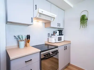 a kitchen with white cabinets and a stove top oven at Stylish One Bedroom Sanctuary in the Greens in Dubai