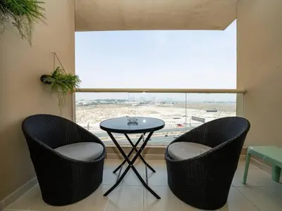 a table and two chairs in a room with a window at Stylish One Bedroom Sanctuary in the Greens in Dubai