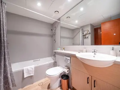 a bathroom with a sink and a toilet and a mirror at Stylish One Bedroom Sanctuary in the Greens in Dubai