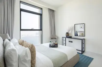 a white bedroom with a large bed and a window at Frank Porter - Marina Vista Tower 2 in Dubai