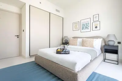 a bedroom with a large white bed and a blue rug at Frank Porter - Marina Vista Tower 2 in Dubai