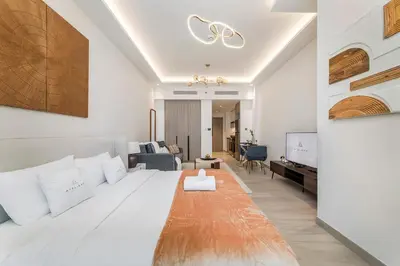 a bedroom with a large bed and a living room at Apartments in ME DO RE Jumeirah Lake Towers in Dubai