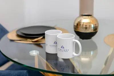 two white coffee mugs sitting on a glass table at Apartments in ME DO RE Jumeirah Lake Towers in Dubai