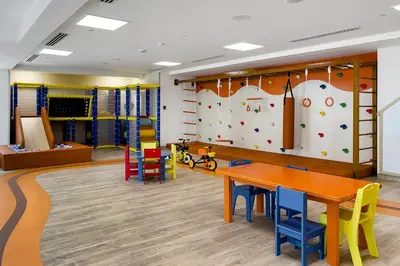 a classroom with a table and chairs and a climbing wall at Apartments in ME DO RE Jumeirah Lake Towers in Dubai