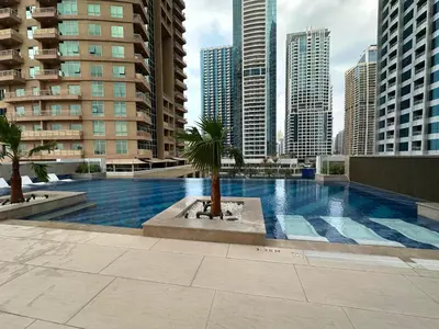 a swimming pool with a palm tree in a city at Apartments in ME DO RE Jumeirah Lake Towers in Dubai