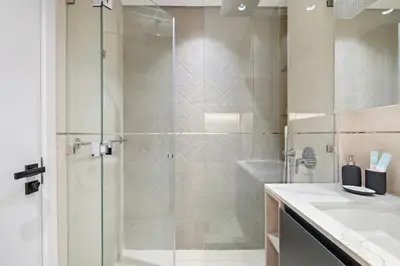 a bathroom with a glass shower and a sink at StoneTree - Modern Apartment - Brand New in Dubai