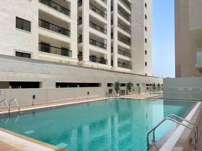 a large swimming pool in front of a building at StoneTree - Modern Apartment - Brand New in Dubai