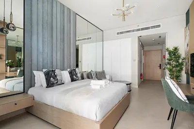 a bedroom with a large white bed and a mirror at StoneTree - Modern Apartment - Brand New in Dubai