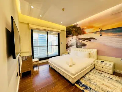 a bedroom with a bed and a painting of a beach at Sea Front Living, Upgraded 2BR Apartment, Escan Tower, Dubai Marina in Dubai