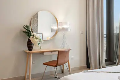 a bedroom with a desk with a mirror and a chair at FIRST CLASS 1BR Burj Khalifa & Fountain Views in Dubai