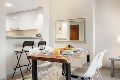 a dining room with a wooden table and white chairs at FIRST CLASS 1BR Burj Khalifa & Fountain Views in Dubai