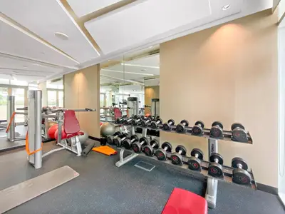 a gym with a row of dumbbells on a wall at Spacious Studio in Business Bay in Dubai