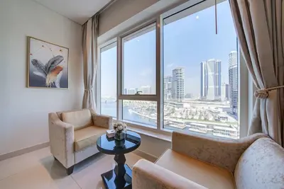 a living room with a couch and chairs and a large window at Business Bay Studio in hotel l Sleek & Modern for 2 in Dubai