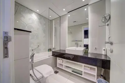 a bathroom with a sink and a tub and a mirror at Business Bay Studio in hotel l Sleek & Modern for 2 in Dubai