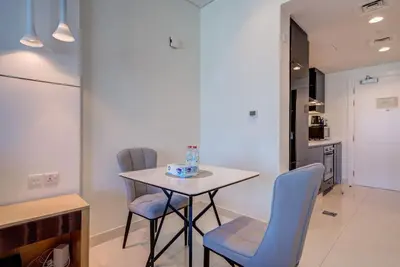 a table and chairs in a room with a kitchen at Business Bay Studio in hotel l Sleek & Modern for 2 in Dubai