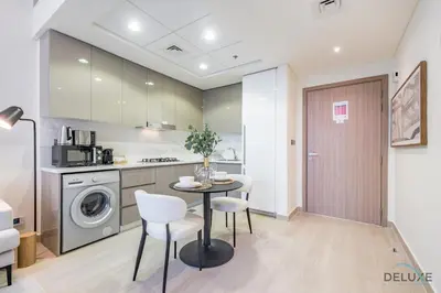 a kitchen and dining room with a table and chairs at Captivating 1BR Apartment in Azizi Riviera 20, Al Merkadh by Deluxe Holiday Homes in Dubai