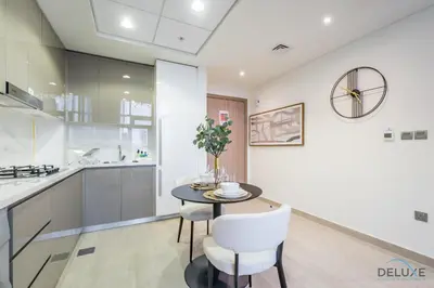 a kitchen and dining room with a table and chairs at Captivating 1BR Apartment in Azizi Riviera 20, Al Merkadh by Deluxe Holiday Homes in Dubai