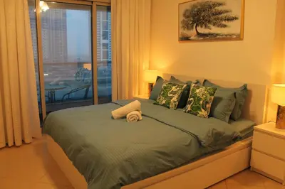 a bedroom with a bed with a view of the city at Bright and beautiful one bedroom apartment close to metro and beach in Dubai