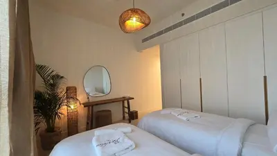 a room with two beds and a mirror at Luxury 2BR Biophilic Retreat with Private Jacuzzi, Massage Chair & Infinity Pool in Dubai