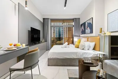 a bedroom with a bed and a living room at FIRST CLASS Studio Stylish Haven in Dubai