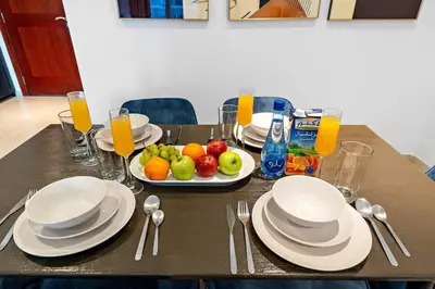 a table with plates and bowls of fruit on it at FIRST CLASS 2BR Elite Urban Retreat in Dubai