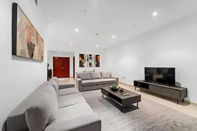 a living room with a couch and a tv at FIRST CLASS 2BR Elite Urban Retreat in Dubai