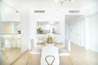 a white dining room with a table and chairs at Marina Tower - Stunning 1BHK with Marina View by Elegant Escape's in Dubai