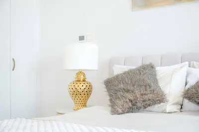 a bedroom with a bed with a lamp and pillows at Marina Tower - Stunning 1BHK with Marina View by Elegant Escape's in Dubai