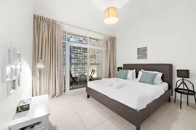 a bedroom with a bed and a large window at Luxury 2BR with Stunning Dubai Marina Views Near JBR Beach in Dubai