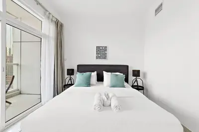 a bedroom with a white bed with shoes on it at Luxury 2BR with Stunning Dubai Marina Views Near JBR Beach in Dubai