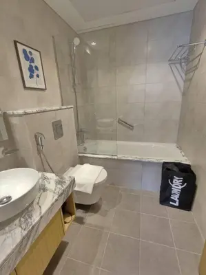 a bathroom with a sink and a toilet and a shower at Upgraded Downtown Dubai 2 BD in Dubai
