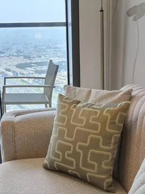 a couch with a pillow in front of a window at Upgraded Downtown Dubai 2 BD in Dubai