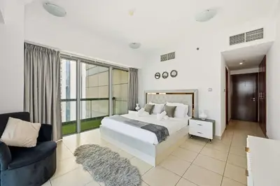 a bedroom with a large bed and a chair at Incredible downtown location in Dubai